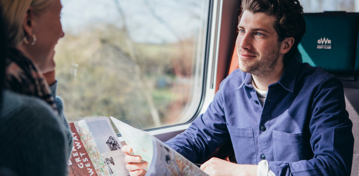 Two People on Great Western Railway with Great West Way Map